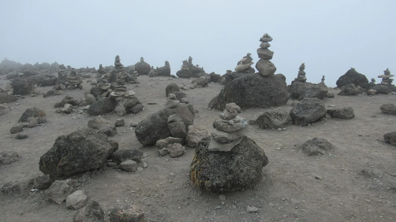 Paesaggio montano arido con rocce e piccole formazioni rocciose in primo piano.
