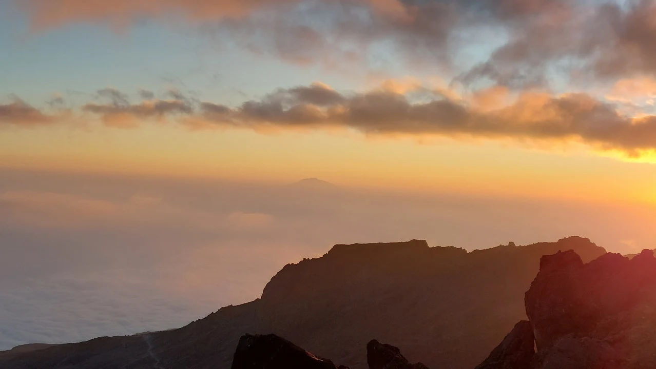 Paesaggio al tramonto sulle montagne del Kilimangiaro con nuvole colorate.