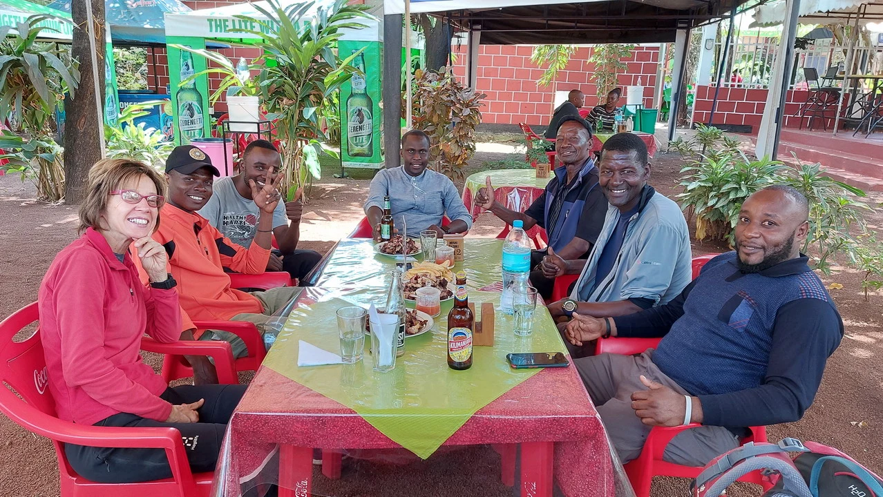 Un gruppo di persone pranza all'aperto in un ambiente safari in Tanzania.