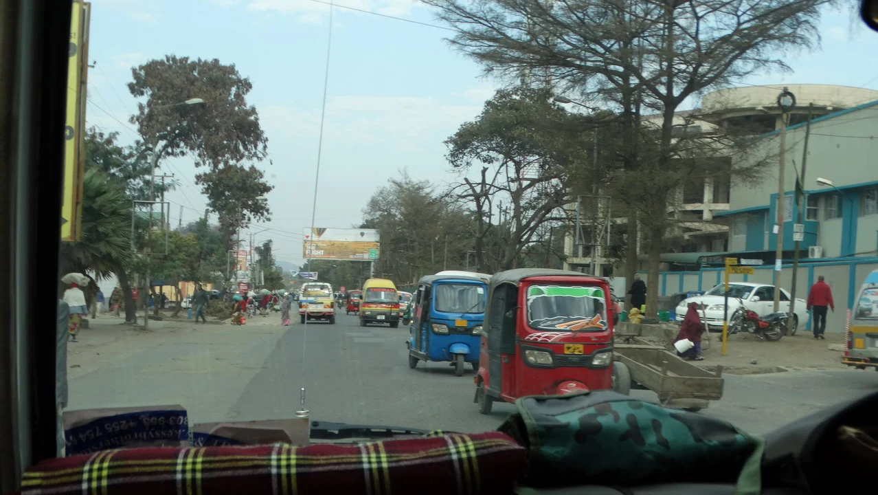 Una scena di strada con veicoli in movimento in una località africana.