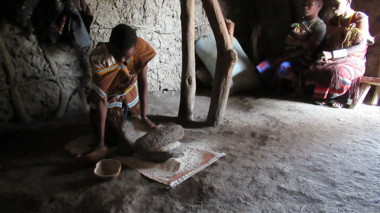 Una famiglia indossa abiti tradizionali mentre lavora sulla terra in un villaggio della Tanzania.