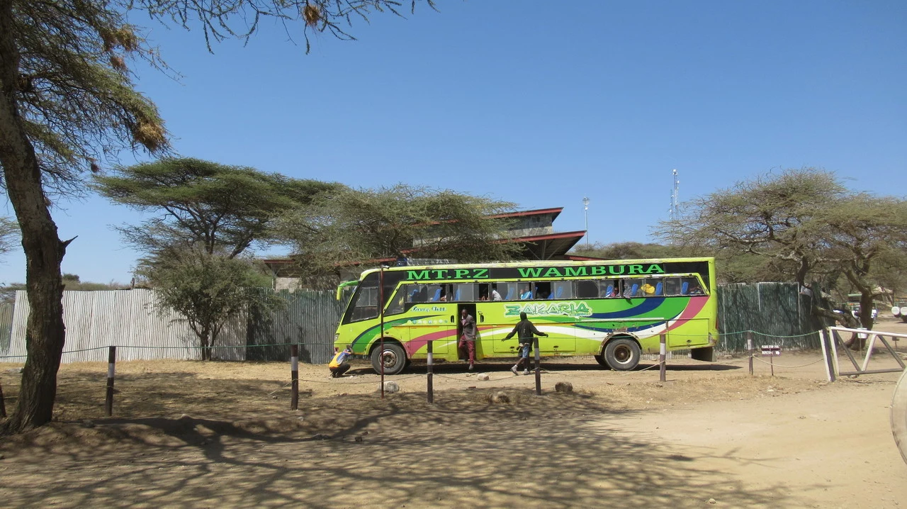 Un autobus verde parcheggiato su un sentiero nella savana della Tanzania.