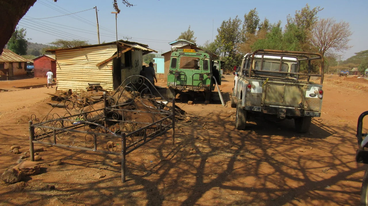 Un veicolo vecchio parcheggiato in un ambiente arido della Tanzania.