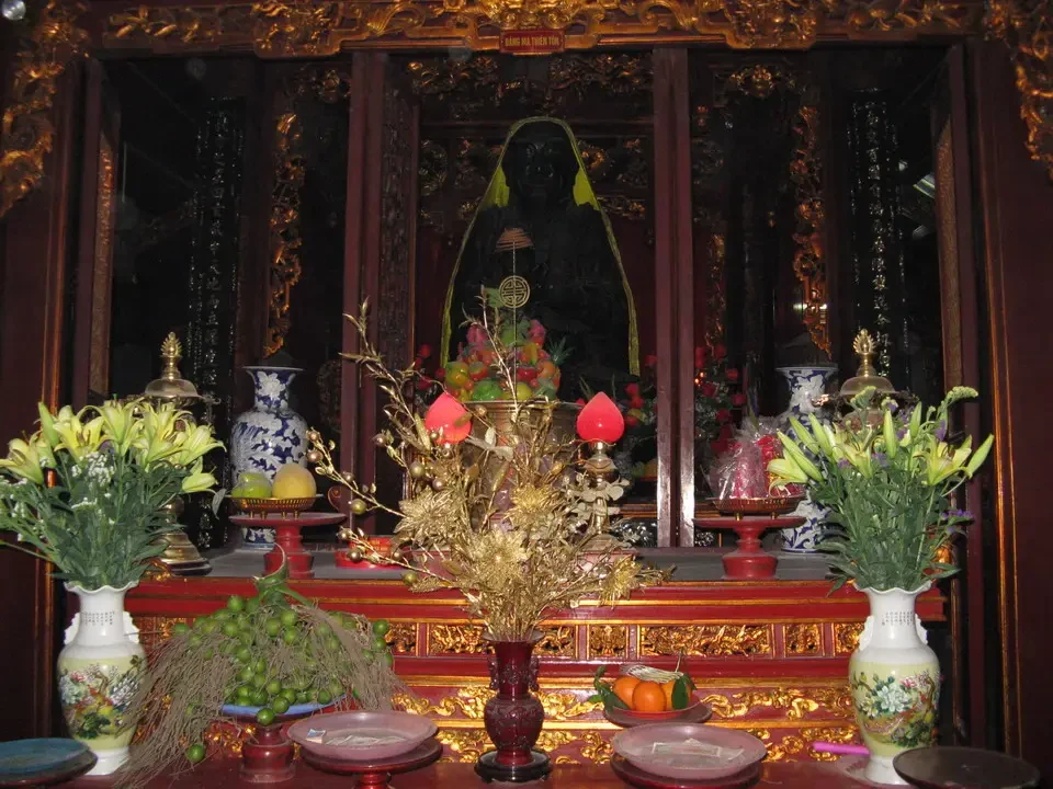 Interni di un tempio o palazzo decorati con oggetti rituali e fiori.