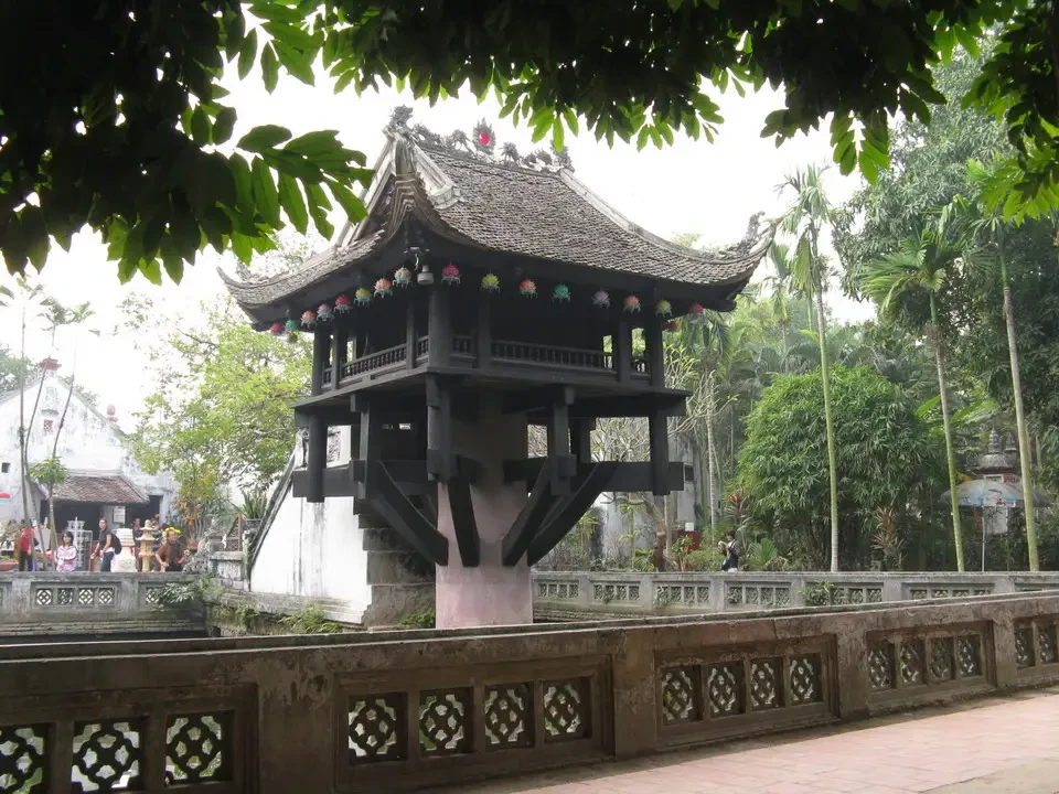 Una pagoda a un solo pilastro in legno si staglia sopra un ponte in stile tradizionale.