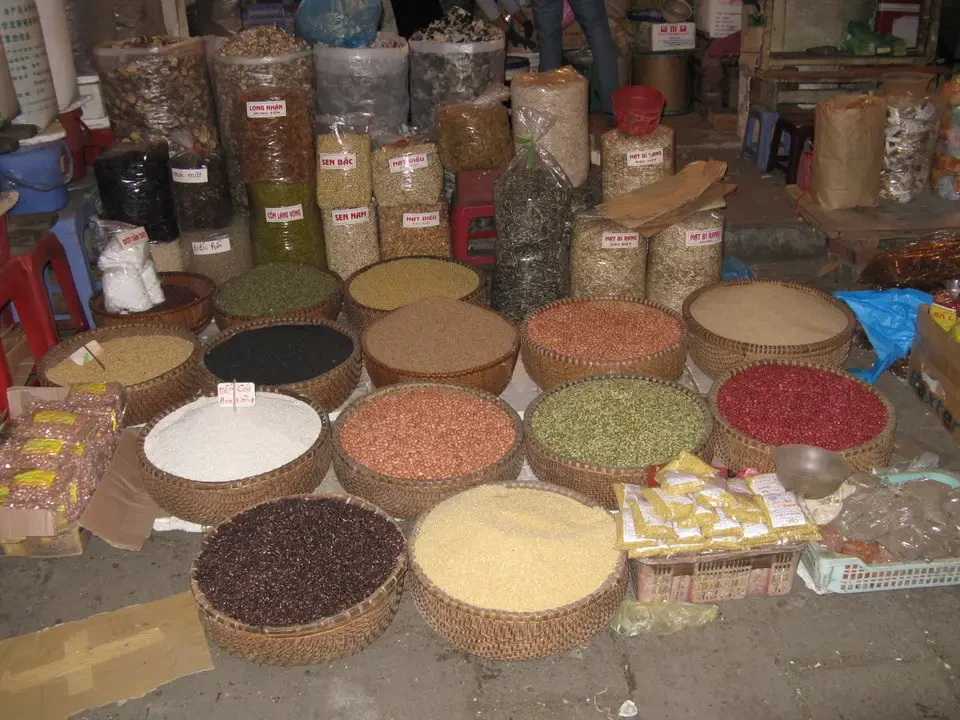 Mercato di Hanoi pieno di prodotti alimentari esposti su balle intrecciate.