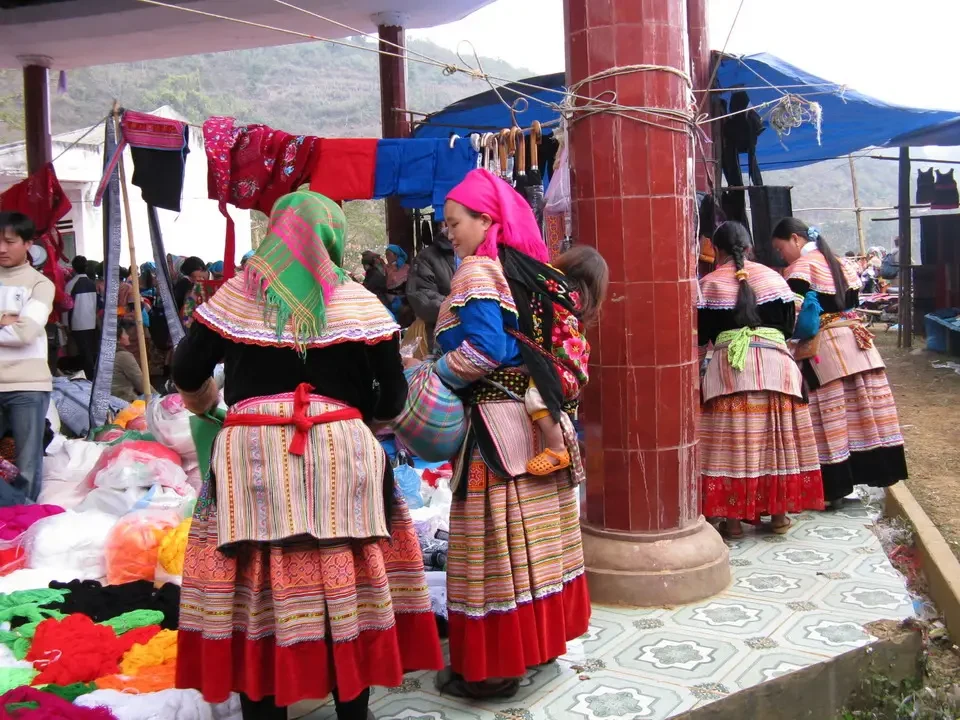 Donne indossano abiti tradizionali colorati in un mercato al Vietnam o in Cambogia.