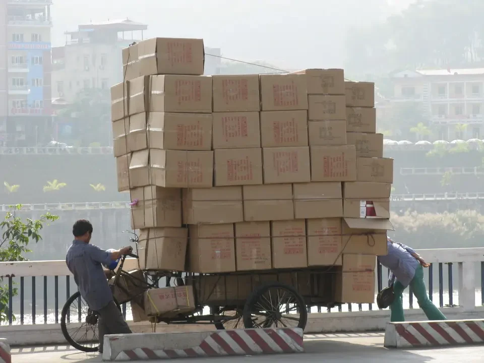 Un carretto carico di scatole trasporta merci su una strada in Vietnam o Cambogia.