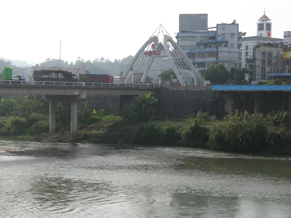 Un ponte attraversa un fiume con edifici sullo sfondo in Vietnam e Cambogia.