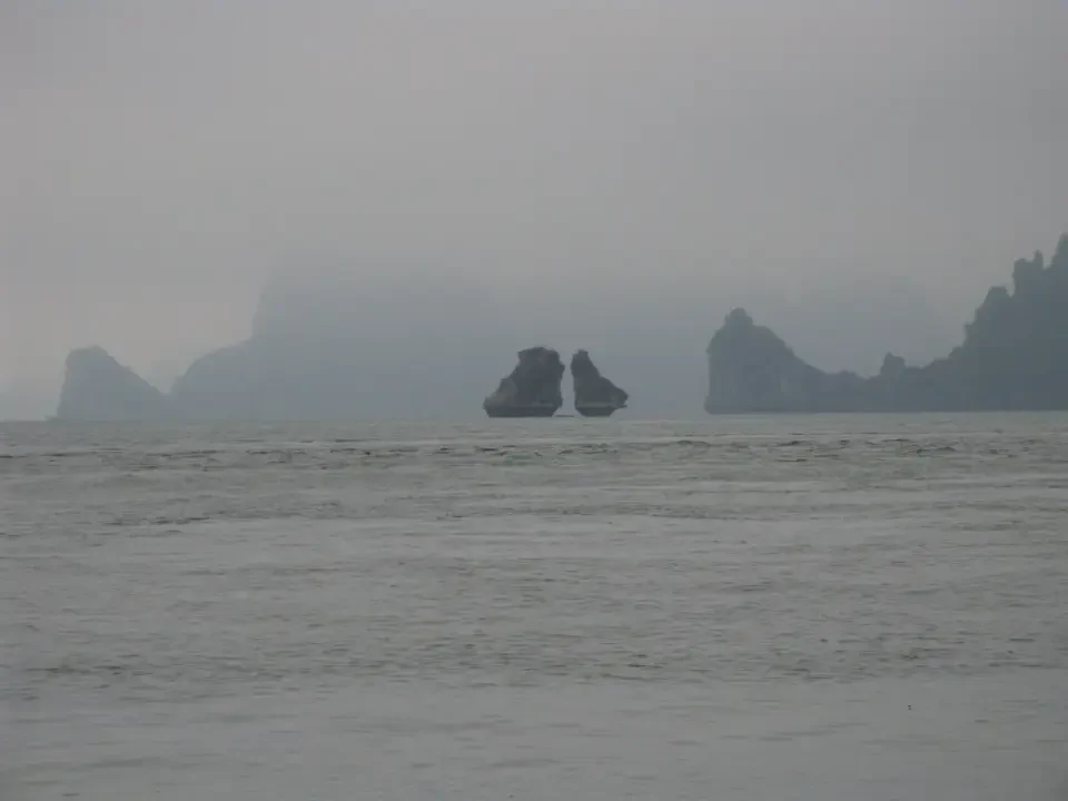 I paesaggi montuosi di isole rocciose emergono nella nebbia del mare.