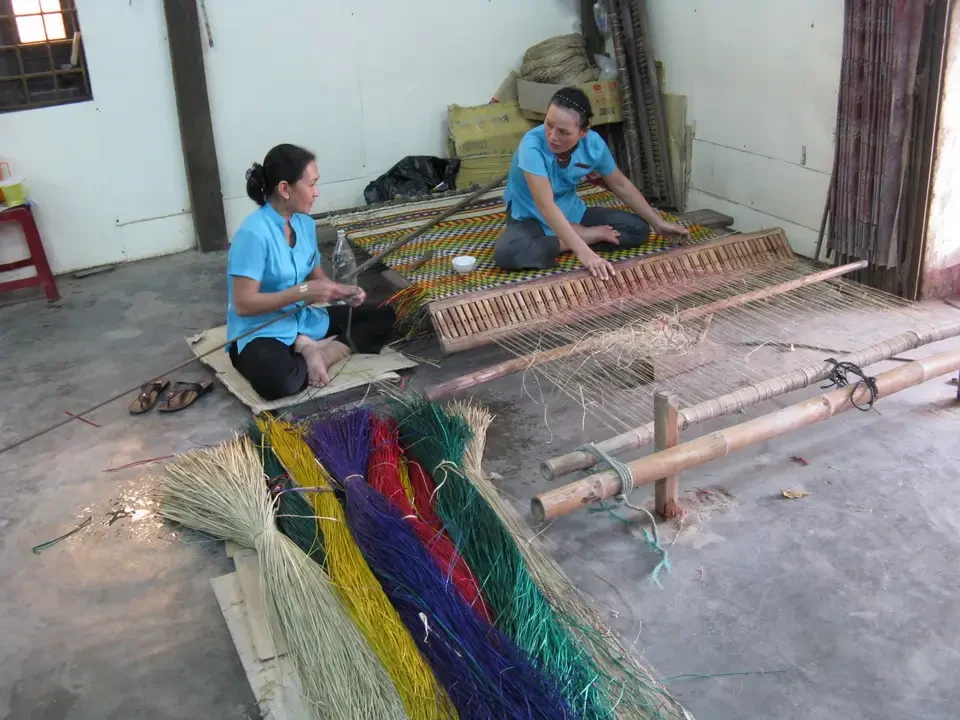Artigiane tessono fibre naturali in un laboratorio in Vietnam o Cambogia.