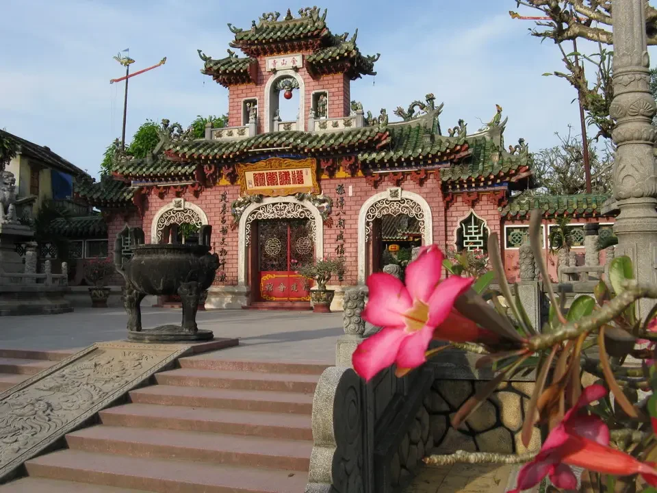 Un edificio tradizionale con tetto rosso in stile vietnamita si trova in un contesto di viaggio.