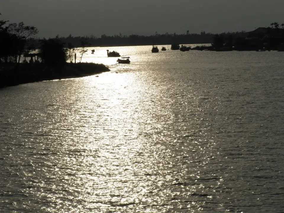 La luce del sole si riflette brillantemente sull'acqua di un fiume in Vietnam o Cambogia.