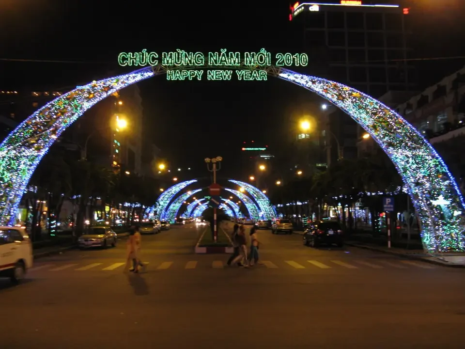Una galleria di luci decorano un ponte in una strada cittadina durante il Capodanno.
