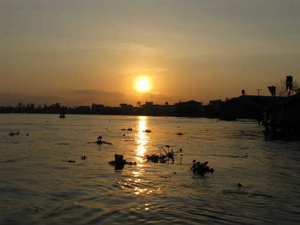 Tramonto sul fiume Mekong con riflessi dorati sull'acqua in Vietnam e Cambogia.