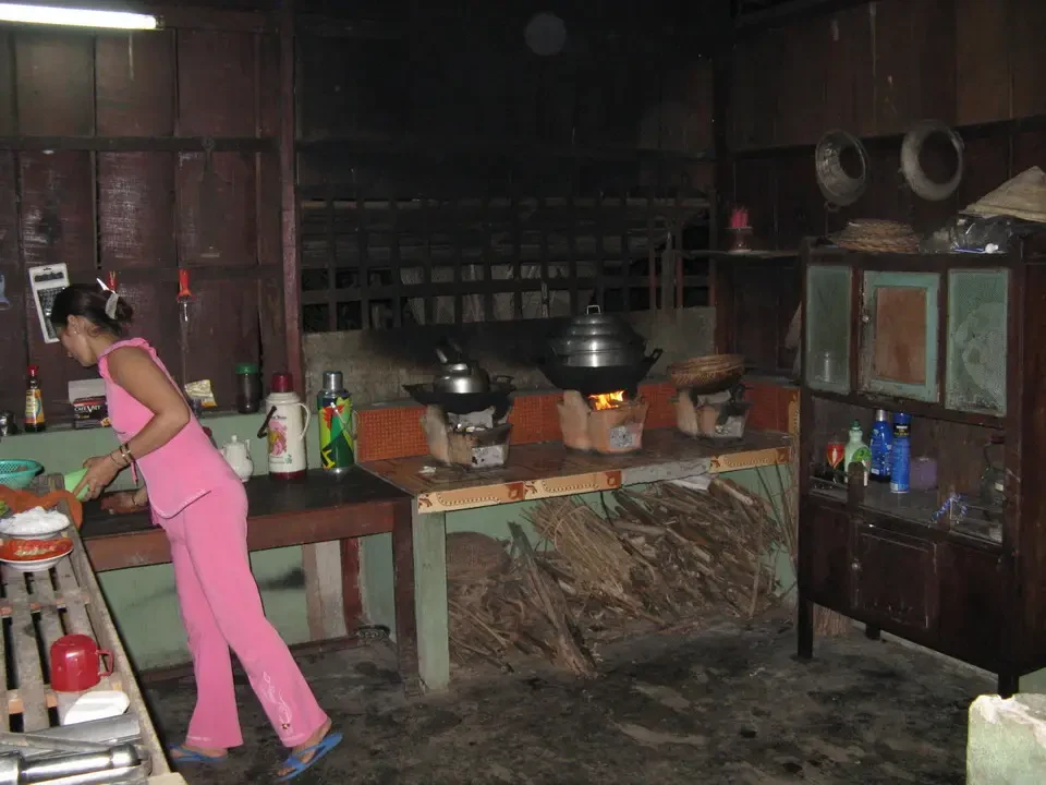 Una persona cucina in un ambiente rustico con utensili da cucina tradizionali.