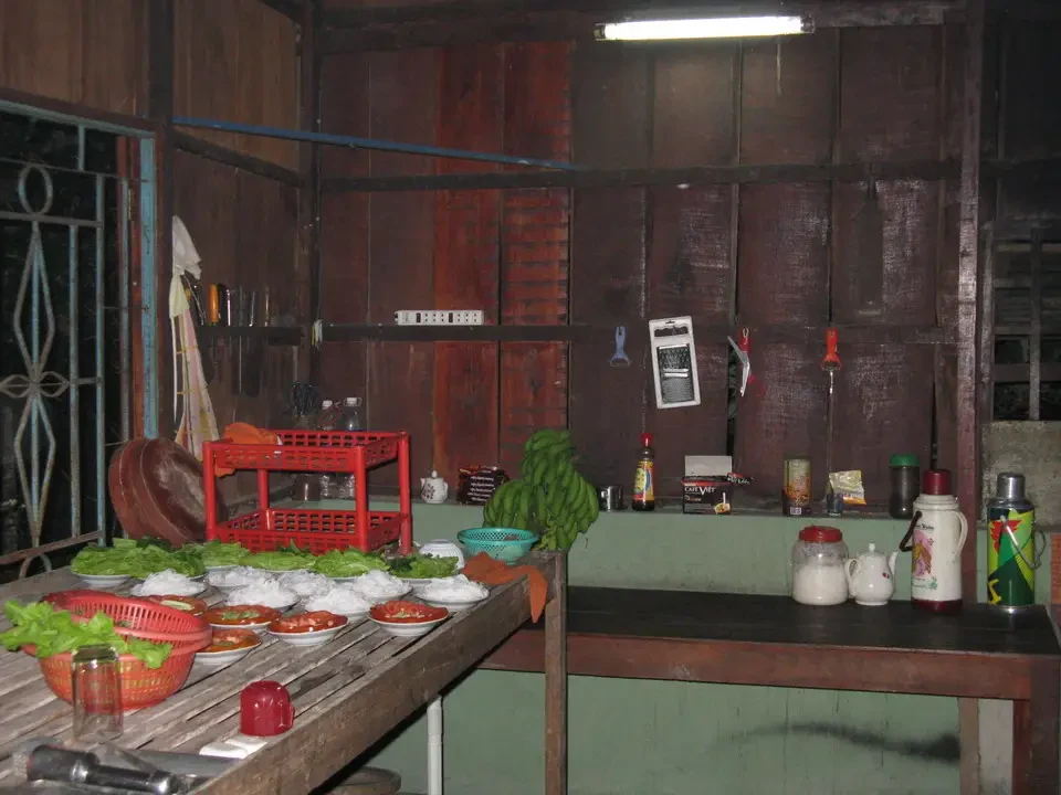 Una cucina rustica in stile tradizionale mostra una preparazione di cibo all'aperto.
