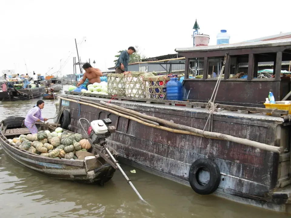 Un mercato galleggiante con frutta e verdura è visibile sull'acqua in Vietnam o Cambogia.