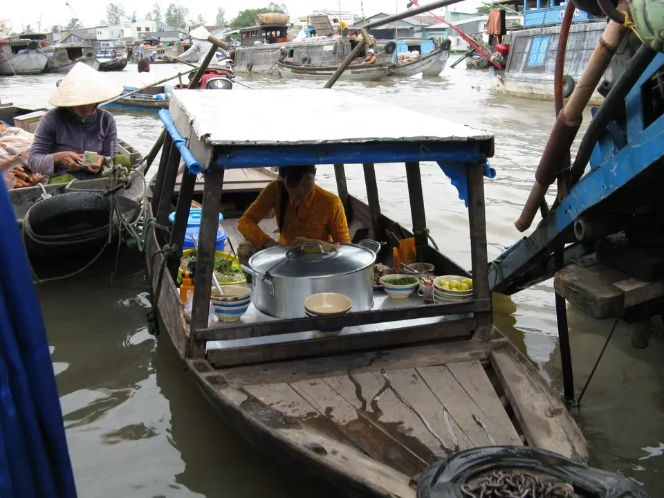 Un mercato galleggiante lungo un fiume in Vietnam o Cambogia.