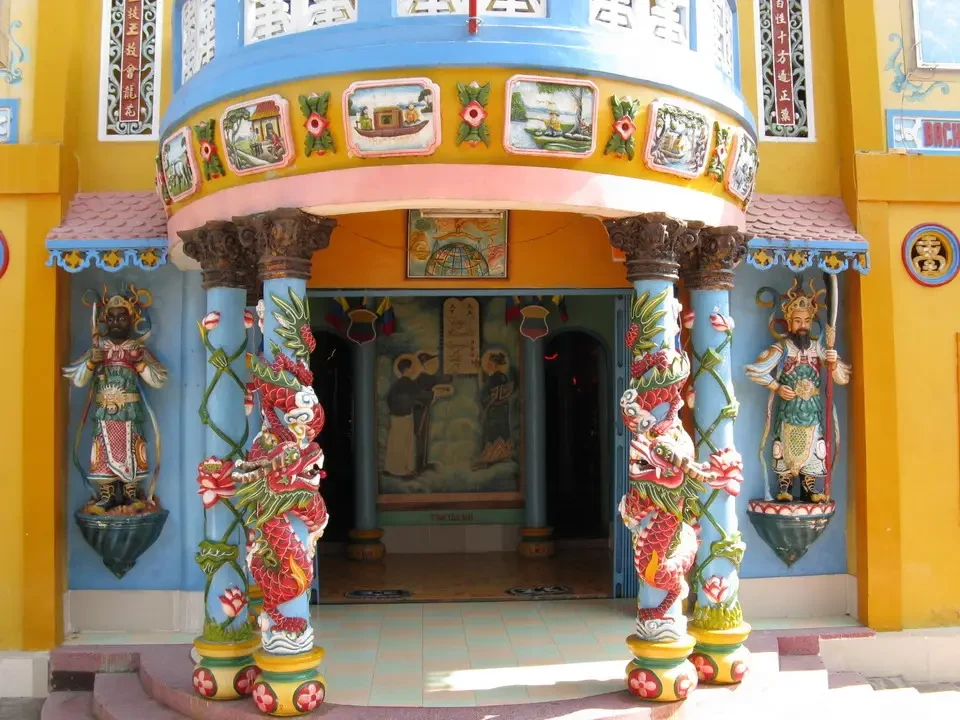 Facciata colorata di un tempio vietnamita o cambogiano con colonne ornate.