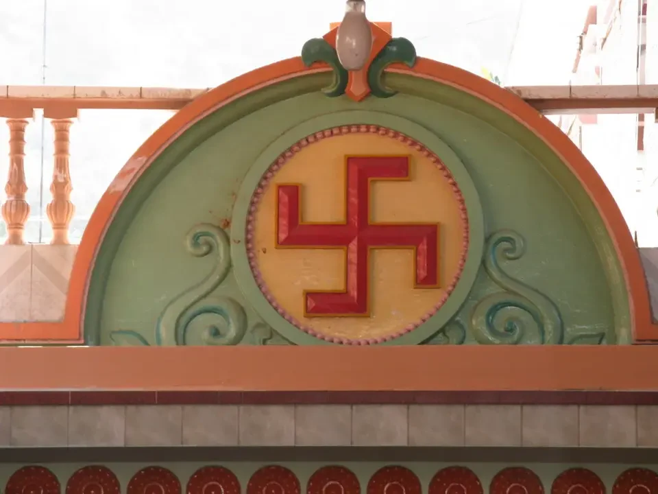 Dettaglio di una facciata con un ornamento architettonico contenente un simbolo.