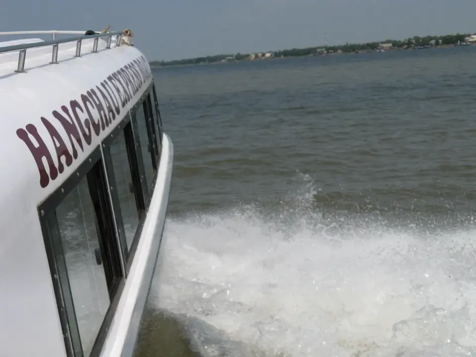 Un autobus naviga sul fiume Mekong con onde bianche.