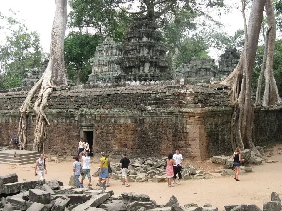 Resti di pietra con radici di alberi dominano un sito archeologico in Angkor.