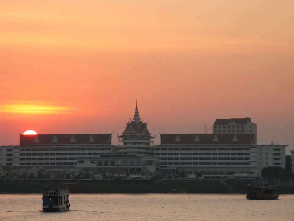 Tramonto sul fiume Mekong con edifici in stile tradizionale a Phnom Penh.