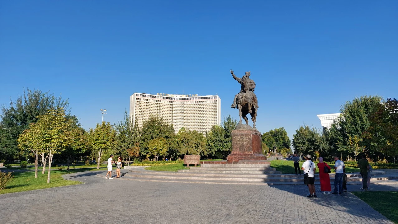 Una vista aperta della piazza con una statua equestre in primo piano e un edificio sullo sfondo.