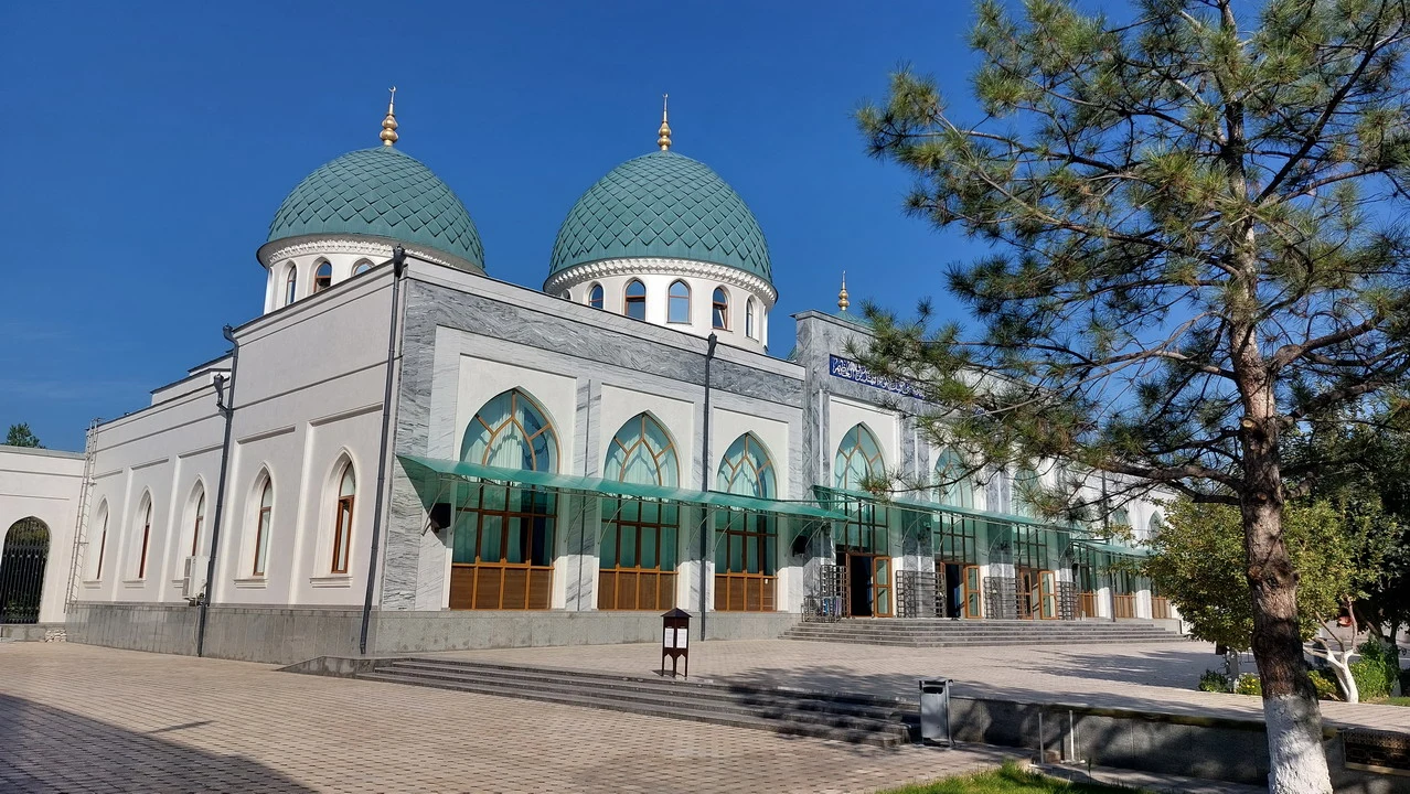 Vista esterna della moschea a Tashkent con cupole verdi e facciata chiara.