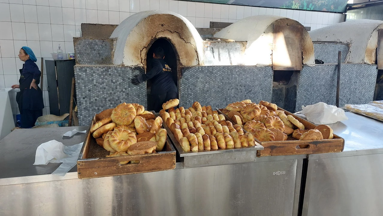 Pane dorato viene sfornato da un forno tradizionale in una panetteria.