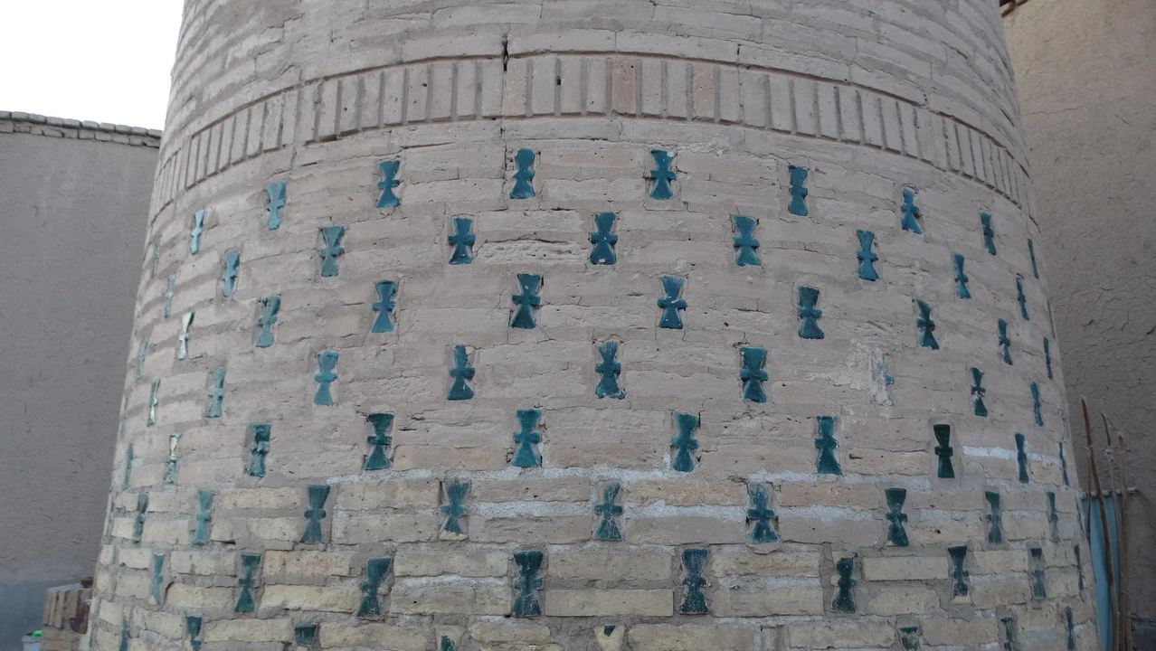 Parete esterna di un edificio con decorazioni geometriche azzurre.