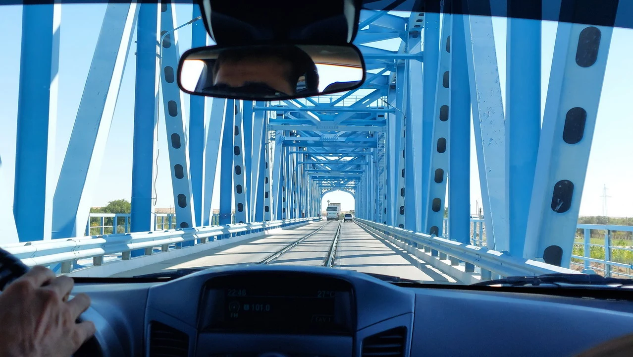 Un ponte blu attraversa un paesaggio lungo il fiume Amu Darya in Asia Centrale.