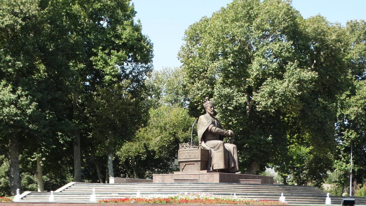 Statua di Amir Timur nel contesto di un parco alberato.