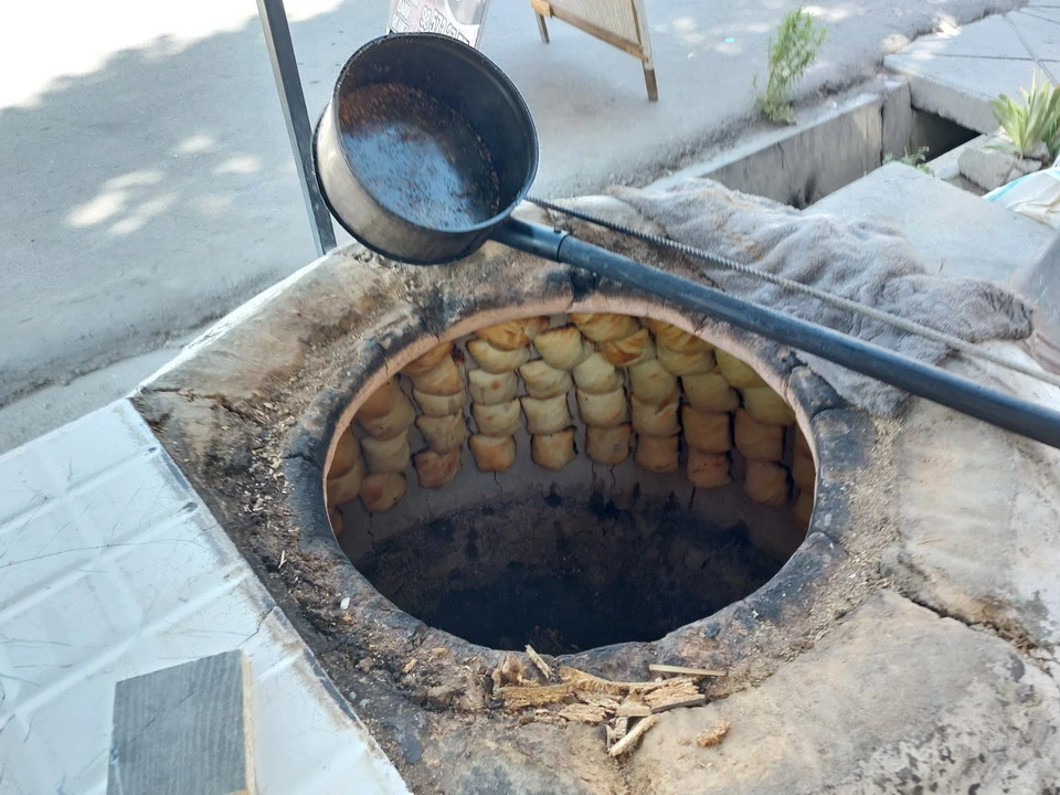 A traditional wood-fired oven with bread baking in Central Asia.