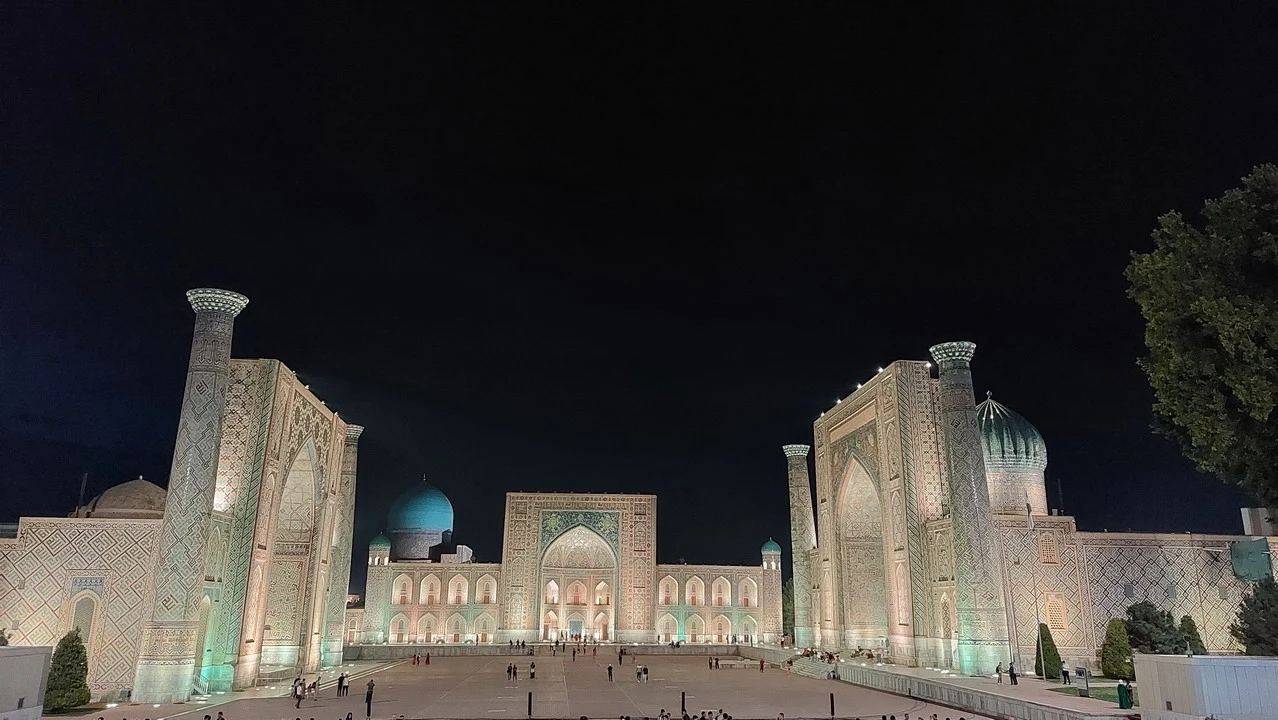 La piazza Registan a Samarcanda illuminata di notte mostra la maestosità dell'architettura islamica.