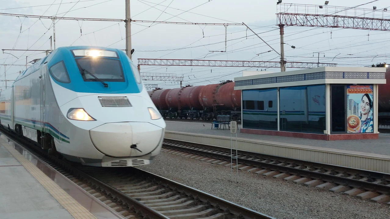 Un treno moderno attraversa una stazione ferroviaria in Asia Centrale.