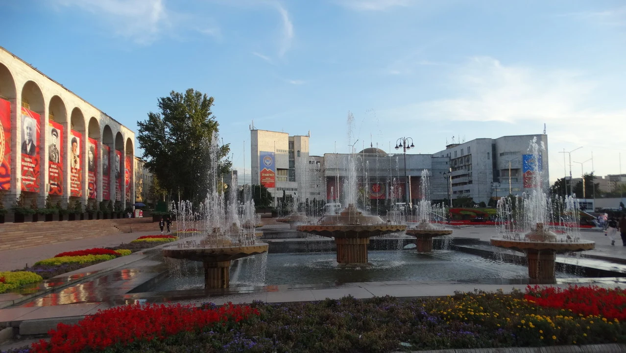 Una veduta ampia della piazza Ala-Too a Bishkek con fontane e edifici circostanti.