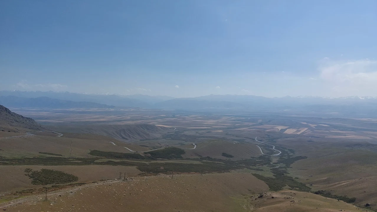 Vasta distesa di terreno secco e colline ondulate si estendono verso l'orizzonte.