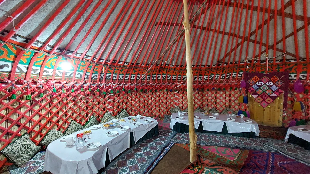 Accampamento in tenda tradizionale con tavoli apparecchiati in Asia Centrale.