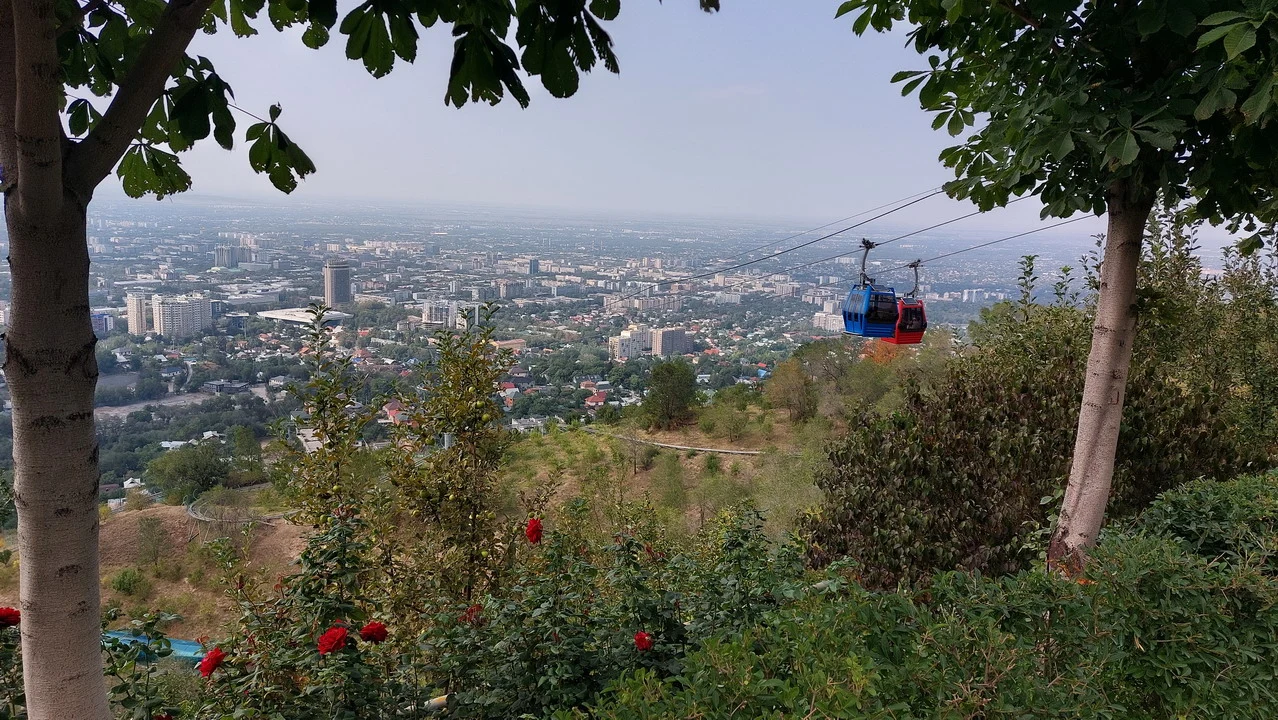 Una vista panoramica della città con una funivia che attraversa il paesaggio collinare.
