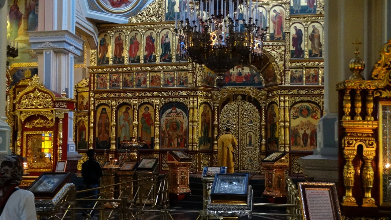 Interno sontuoso di una chiesa riccamente decorata con affreschi dorati.