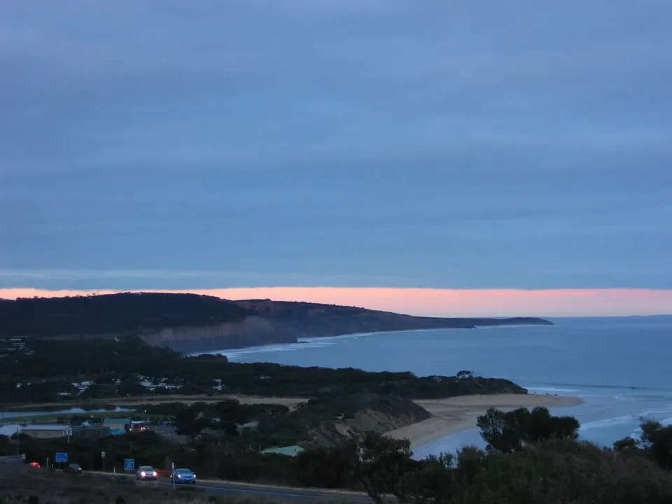 Paesaggio costiero australiano al tramonto con la costa e la spiaggia visibili.