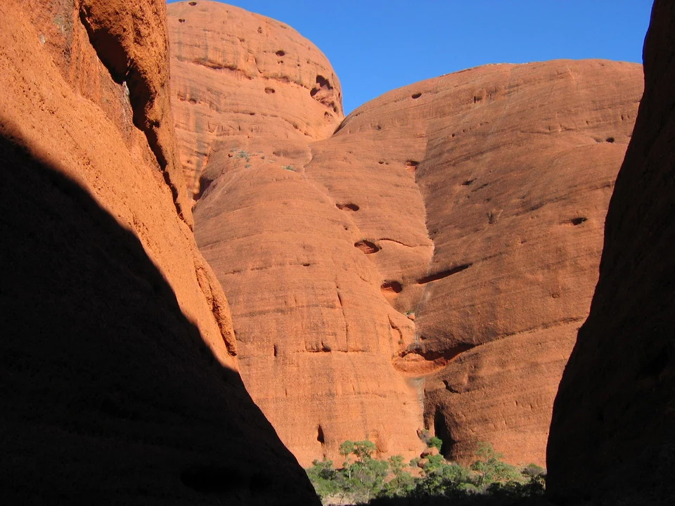 Formazioni rocciose rosse e ondulate sotto un cielo blu brillante in Australia.