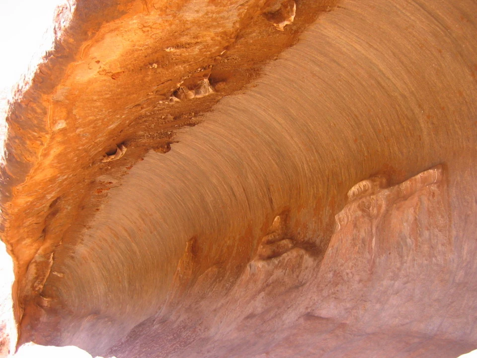 Vista ravvicinata di una formazione rocciosa allungata e ondulata nel deserto australiano.