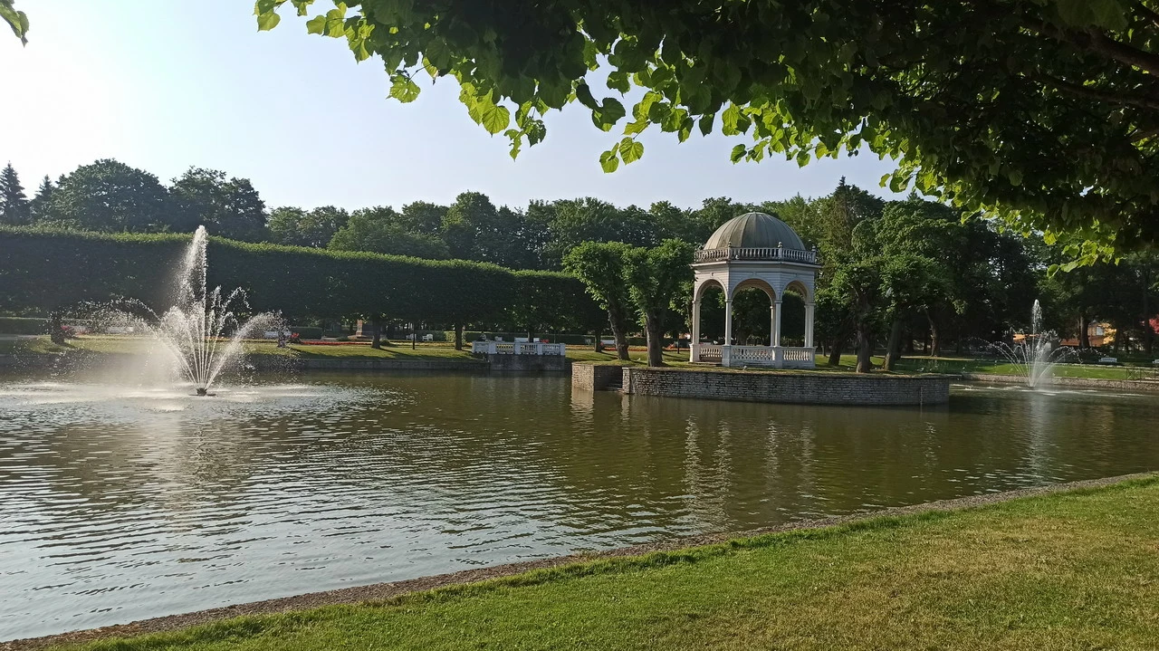 Un parco con fontane e una struttura in stile ottomano si estende lungo un corpo d'acqua.