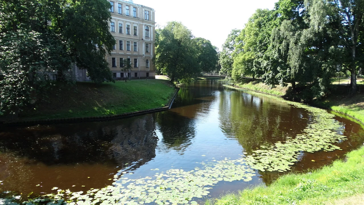 Un canale sereno con alberi e un edificio in stile classico lungo la riva.