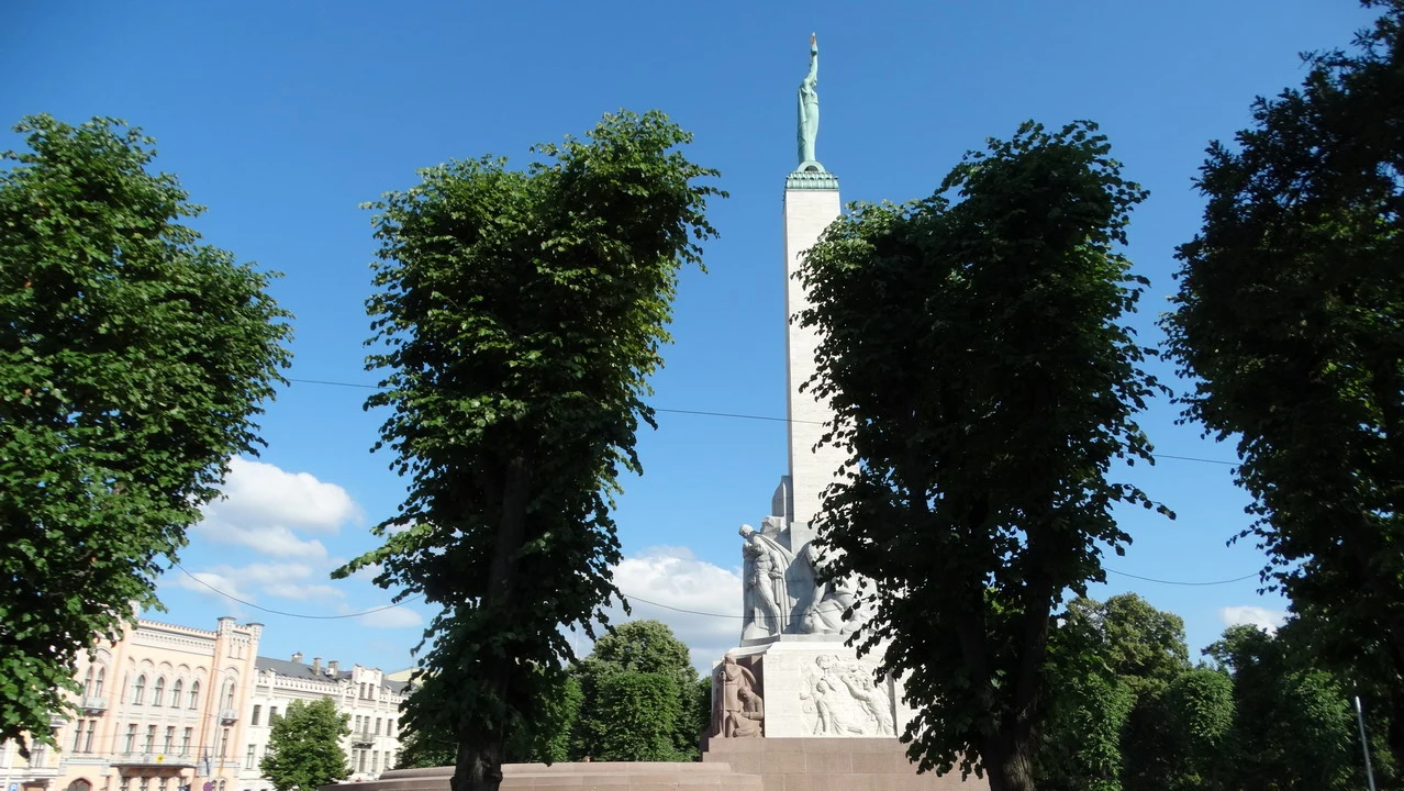 Una vista della Monumento della Libertà a Riga circondata da alberi lussureggianti.