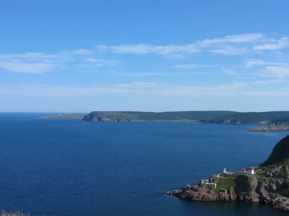 Panorama marino di coste rocciose e isole sotto un cielo azzurro.