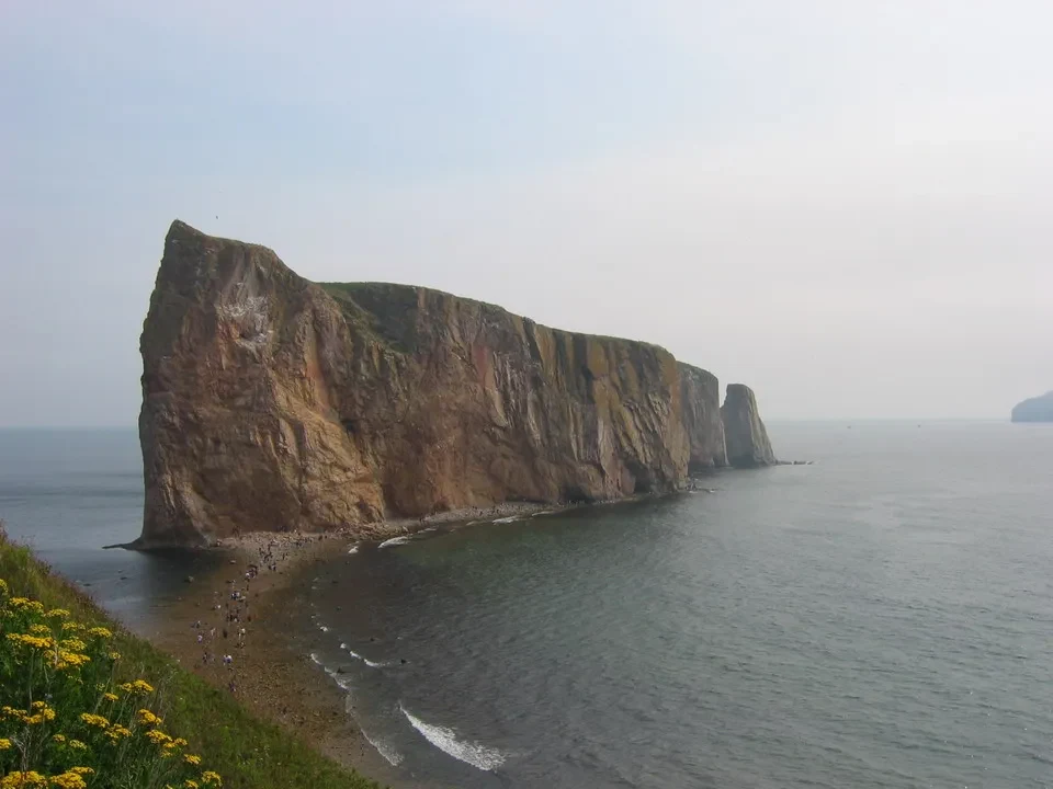Falesie rocciose e scogli si protendono nell'acqua del mare.